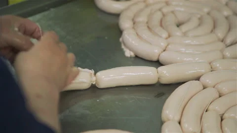 Workers in meat factory forming many short sausages from one long sausage. Sausa Stock Footage 131864922