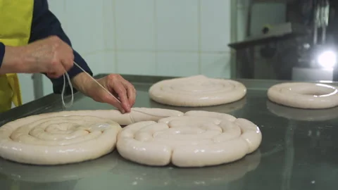 Workers in meat factory forming many short sausages from one long sausage. Vídeo Stock 131865892