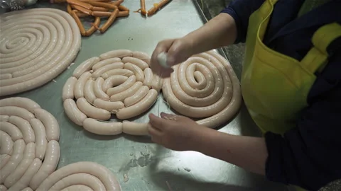 Workers in meat factory forming many short sausages from one long sausage. Stock Footage 131868607