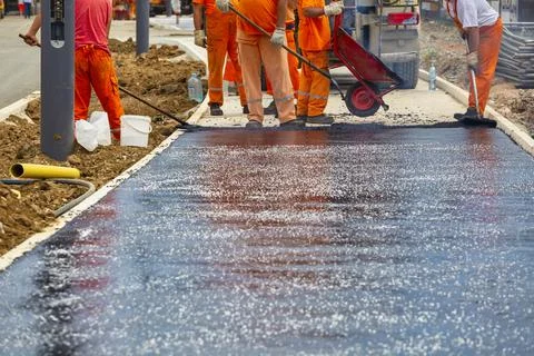 Workers melting and placing asphalt pavement Stock Photos