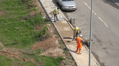 Workers men load sand into wheelbarrow and pave lay tiles. 4K 스톡 동영상 56716782