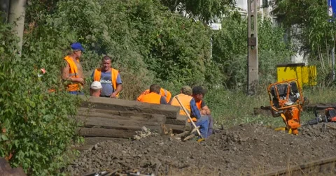Workers Men in Orange Workwear Have a Rest Smoking Sitting Talking Break Stock Footage 55111565