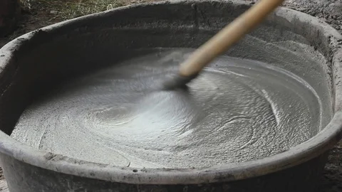 Workers mix cement in black plastic basin. Stock Footage 91785144