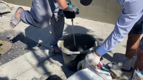 Workers mix cement for wall repair. Vladivostok, Russia, August 8, 2025. Stock Footage 314535595