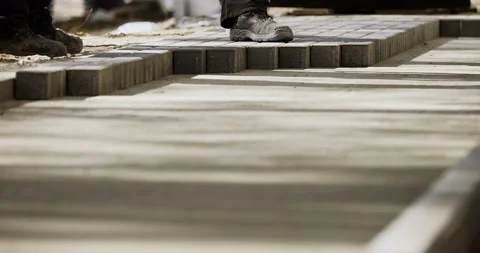 Workers on a modern construction site putting cobble stones on a sidewalk Stock Footage 89935259