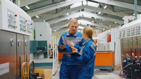 Workers in a modern factory discuss operation of a CNC machine. Engineers Video stock 278269640