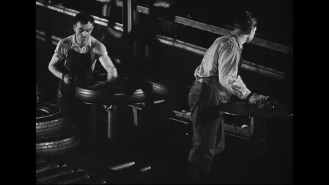 Workers mold rubber tyres and put on conveyor belt for further processing - 1939 Stock Footage 101927324