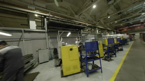 Workers move actively between machines while managing tasks Stock Footage 329030885