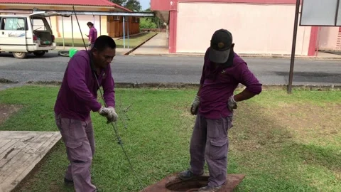 Workers move the manhole cover to clean the sewer line for clogs Stock Footage 101180159