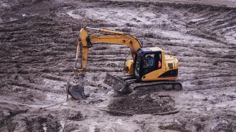Workers in the mud of a construction site at the stage of excavation; constru Stock Photos
