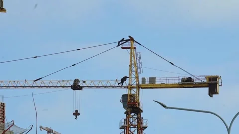Workers operate a construction crane at a building site in the city during the d Stock Footage 331245268