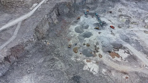 Workers operate machinery in a large quarry during daylight in a busy rock Stock Footage 340166773