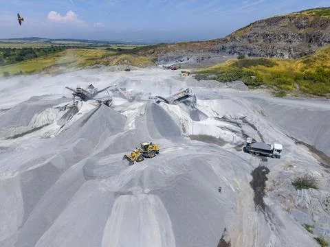 Workers operate machinery in a mining site for materials and minerals Stock Photos