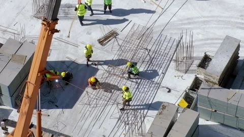 Workers in orange and yellow uniform at the construction site on gray background Video stock 236474335