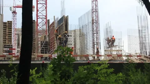 Workers in orange helmets on a construction site. house construction Stock Footage 136107538