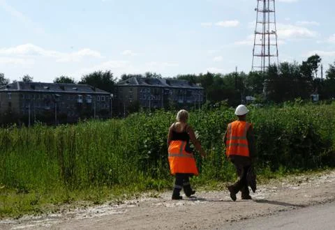 Workers in orange overalls are back from lunch Stock Photos