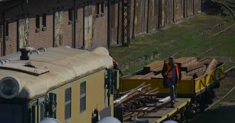 Workers in Orange Workwear Workers on Yellow Locomotive Platphorm with Railroad Stock Footage 55296807