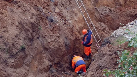 Workers in overalls. Replacement of sewer and water pipes in the city. Emergency Stock Footage 137918207