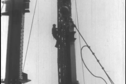 Workers place and fix the structural beam to build tower - 1930 Stock Footage 104336504