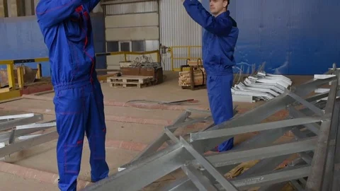 Workers at the plant load the cargo onto the hook of the crane against the Stock Footage 84774427