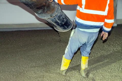 Workers pour mortar onto the floor to level it Stock Photos