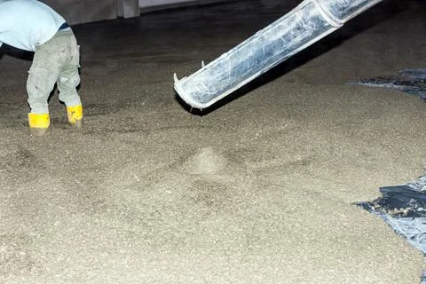 Workers pour mortar onto the floor to level it Stock Photos