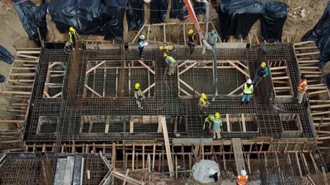 Workers pouring concrete into foundation structure Vidéo 333719657