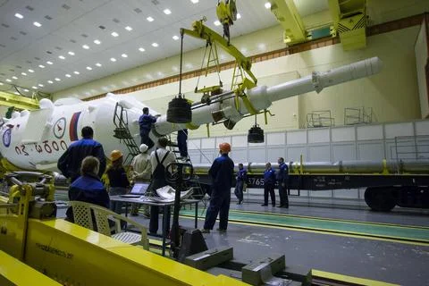 Workers prepare to attach the escape tower to the Soyuz MS-02 spacecraft d... Stock Photos
