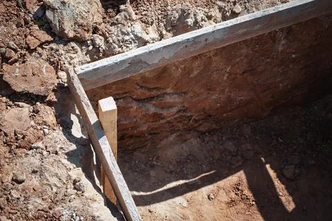 Workers prepare a foundation at a construction site, revealing freshly excava 스톡 사진