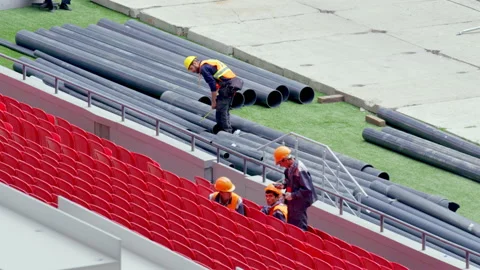 Workers prepare pipes and seats of tribune for pool Stock Footage 231223701