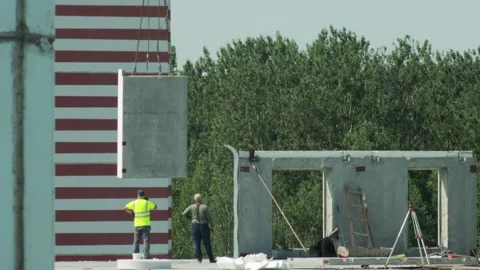 Workers Prepare To Receive Concrete Panel. Crane Lowers Prefabricated Wall At Video stock 322094888