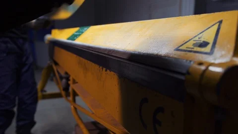 Workers in production using a machine bend sheets of metal. Stock Footage 108648643
