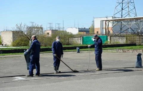 Workers in protective clothes decontaminating square Stock Photos