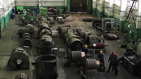 Workers in protective helmets repair huge old electric motors Stock Footage 125547940