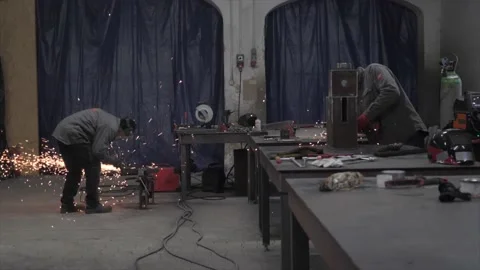 The workers in protective masks welding and grinding metal parts Vídeo Stock 228785458