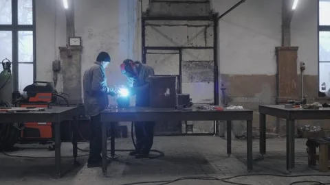 The workers in protective masks welding and grinding metal parts Stock Footage 265190626