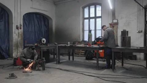 The workers in protective masks welding and grinding metal parts Stock Footage 265190756