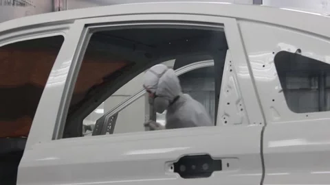 Workers in protective suits and respirators wipe the car body on the conveyor Stock Footage 122335653