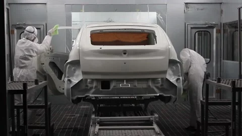 Workers in protective suits and respirators wipe the car body on the conveyor Stock Footage 122335798