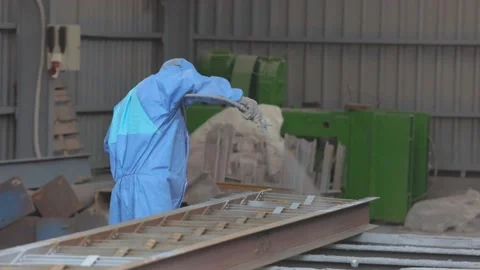 Workers in protective suits paint a metal part. Part painting at the factory Видео 144246737