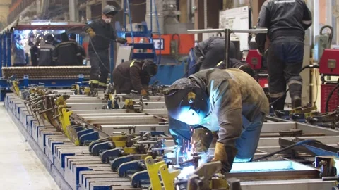 Workers in protective uniform and safety masks are welding steel structures and Stock Footage 202048976