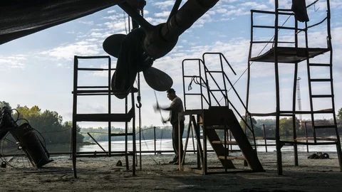 Workers pull a shaft with a screw in a dry dock Stock Footage 86786678
