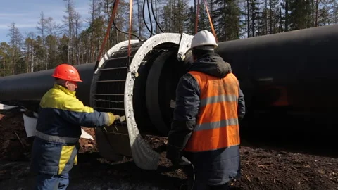 Workers put a clamp on a new gas pipeline. Stock Footage 171878450