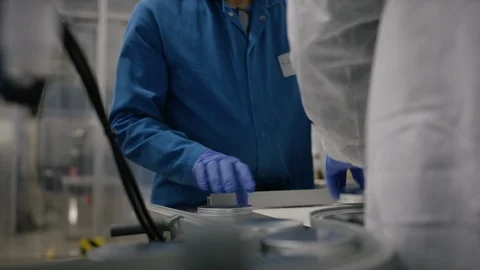 Workers putting lid on cosmetic boxes in factory Stock Footage 107994329