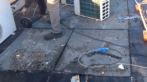 Workers remove the damaged bituminous layer from the flat roof of a building Vídeo Stock 122986295