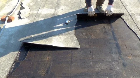 Workers remove the deteriorated bituminous sheath attached to the floor Stock-Footage 90783882