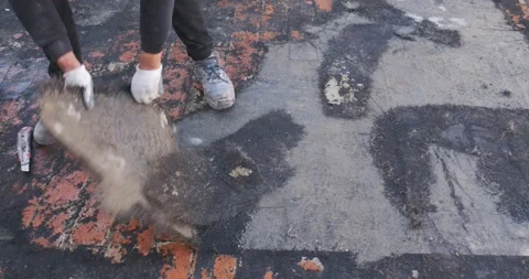 Workers remove the deteriorated bituminous sheath attached to the floor of a  Vídeo Stock 168349069