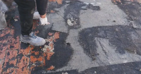 Workers remove the deteriorated bituminous sheath attached to the floor of a  스톡 동영상 168349100