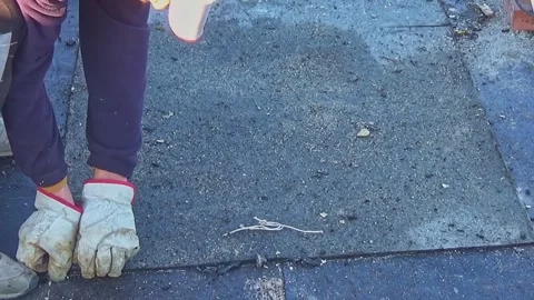 Workers remove the deteriorated bituminous sheath attached to the floor of a  Stock-Footage 291948244