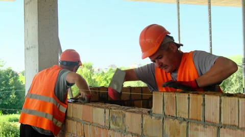 Workers remove excess mortar from cracks in bricks Stock Footage 317605861